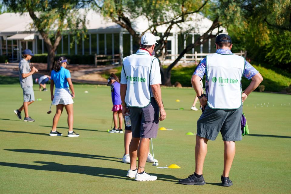 Volunteer caddies watch the 100-hole Putt-a-Thon at Legacy Golf Resort on June 11, 2022, in Phoenix, AZ.