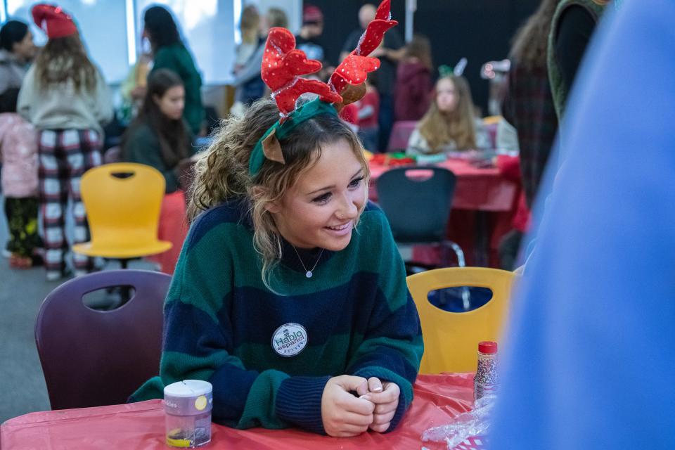 Rocky Mountain High School student Payton Bell speaks Spanish with a family during the school's annual Adopt-A-Family distribution event on Saturday.