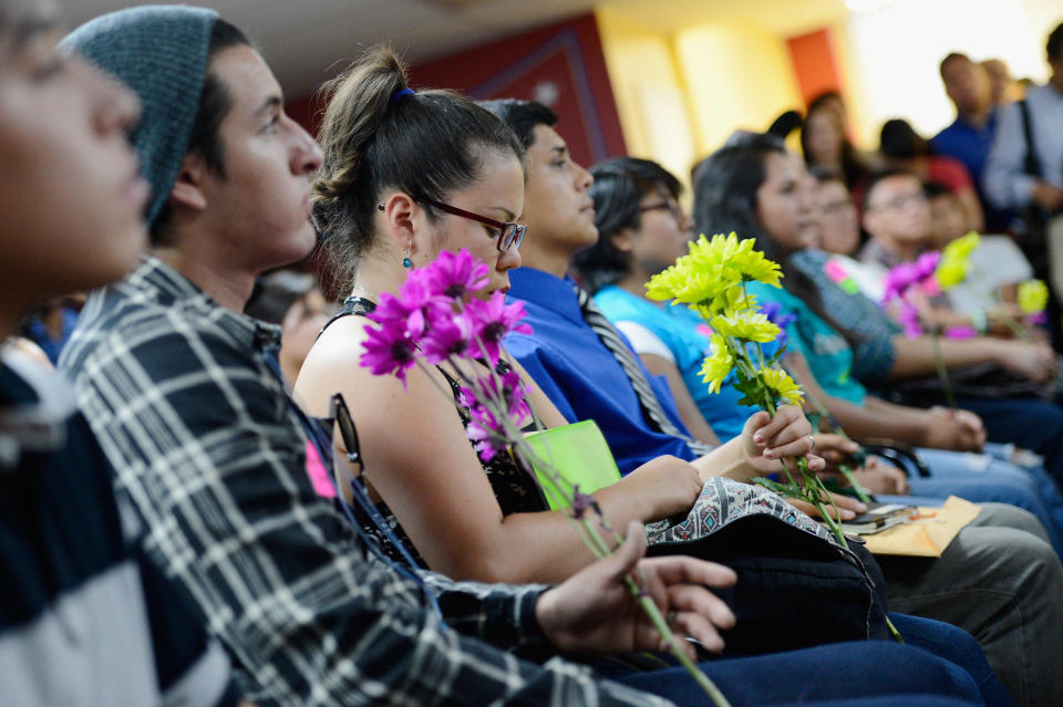 A group of immigrants, known as Dreamers, hold flowers as they listen to a news conference to kick off DACA at the Coalition for Humane Immigrant Rights of Los Angeles on August 15, 2012, in Los Angeles. / Credit: Kevork Djansezian / Getty Images