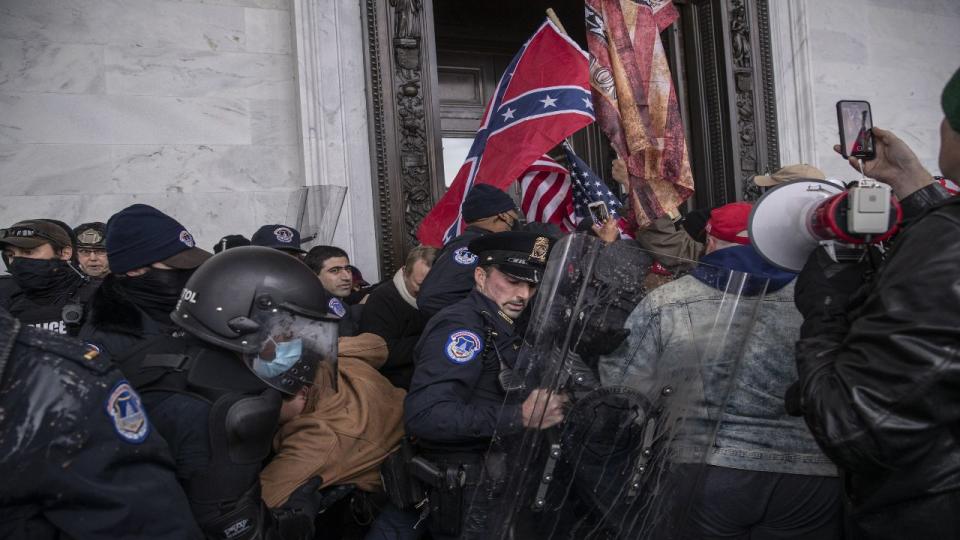Demonstrators clash with U.S. Capitol police officers while trying to enter the Capitol building during a protest outside of in Washington, D.C., U.S., on Wednesday, Jan. 6, 2021. The U.S. Capitol was placed under lockdown and Vice President Mike Pence left the floor of Congress as hundreds of protesters swarmed past barricades surrounding the building where lawmakers were debating Joe Biden's victory in the Electoral College.