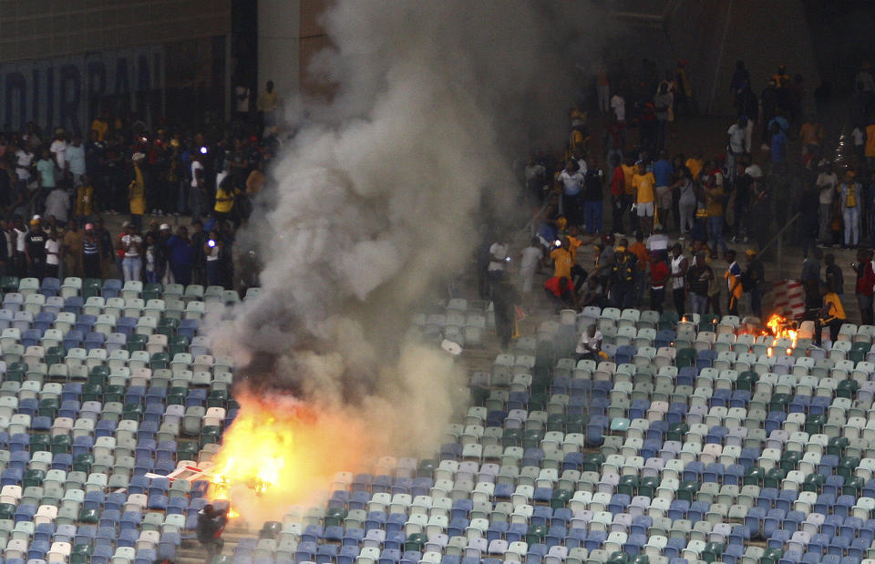 A fire burns in the stands at the Moses Mabhida stadium in Durban, South Africa after violence broke out at a soccer game when hundreds of fans ripped up parts of the stadium, invaded the pitch, and assaulted at least one security guard. (AP Photo)