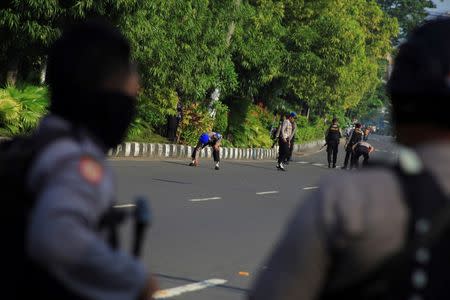 Police comb the street looking for bomb fragments outside a police station following an attack in Solo, Central Java, Indonesia on July 5, 2016 in this photo taken by Antara Foto. Antara Foto/Maulana Surya/via REUTERS