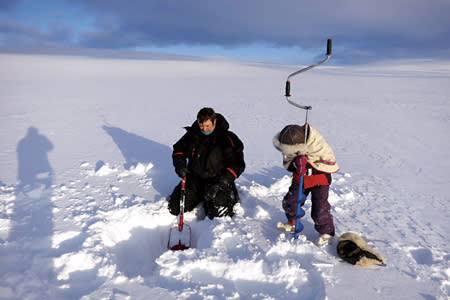 我們在結冰湖上，用一米半的長鑽子不斷旋轉，半個小時後終於鑽出一個小洞釣魚（朱建銘攝影）