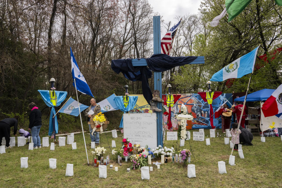 A memorial site to honor the construction workers who lost their lives in the collapse of the Francis Scott Key Bridge sits on the side of the road near the blockade to Fort Armistead Park, in Baltimore, Saturday, April 6, 2024. Roberto Marquez, an artist from Dallas, painted a mural in their honor as well as painted their names on several crosses dotting the perimeter of flowers, candles and other items of remembrance. Members of the community honored the victims through prayer and song. (Kaitlin Newman/The Baltimore Banner via AP)