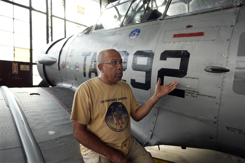 Tuskegee Airmen National Museum President Brian Smith is photographed next to a trainer, Thursday, Aug. 17, 2023, at the Coleman A. Young airport in Detroit. The museum also operates the Tuskegee Airmen Flight Academy, a program designed for youth ages 14-19 who want to become professional pilots. It offers year-round flight instruction and ground school classes leading to a private pilot license. (AP Photo/Carlos Osorio)