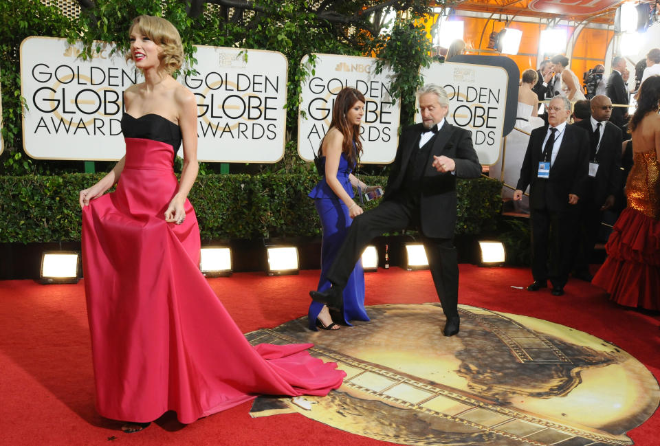 Taylor Swift, left, and Michael Douglas arrive at the 71st annual Golden Globe Awards at the Beverly Hilton Hotel on Sunday, Jan. 12, 2014, in Beverly Hills, Calif. (Photo by Jordan Strauss/Invision/AP)