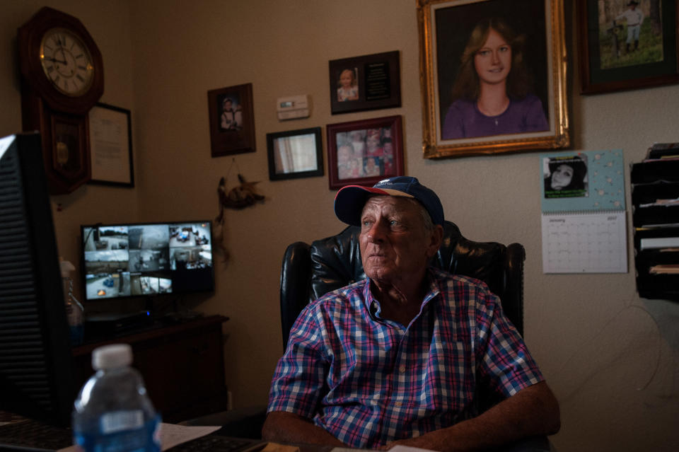 Tim Miller sits in his office in front of a portrait of his daughter, Laura. Miller founded EquuSearch in 2000 in honor of Laura, who was abducted and murdered in 1984. (Photo: Joseph Rushmore for HuffPost)