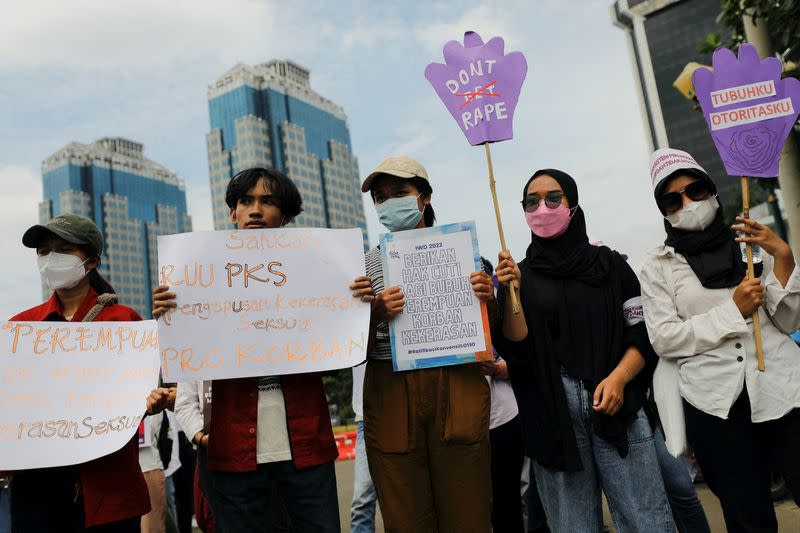 FILE PHOTO: Activists carrying placards take part in a rally to support women's rights calling for gender equality and to protest against gender discrimination, during the International Women's Day outside the National Monument (Monas) complex in Jakarta