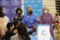 Hawaii Gov. David Ige, center, his wife Dawn Amano-Ige, left, and first lady Jill Biden, right, tour a COVID-19 vaccination clinic at a high school in Waipahu, Hawaii, Sunday, July 25, 2021. (AP Photo/Caleb Jones)