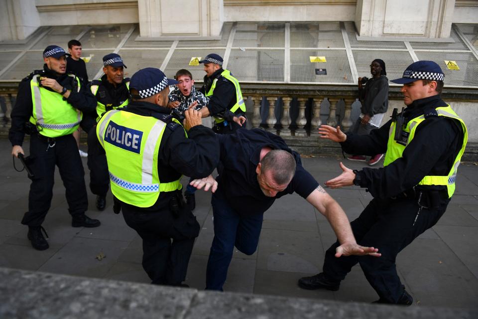 Police officers remonstrate with demonstrators on Parliament Square