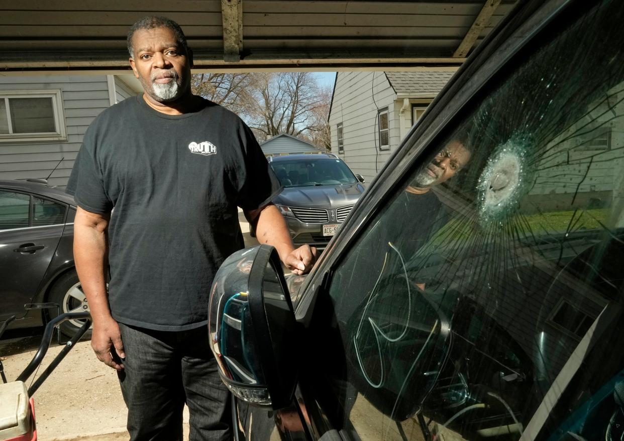 Pastor Kevin Simmons, who was shot during a carjacking in Milwaukee last fall, stands next to the vehicle he was in with a bullet hole in the driver’s side window at his Milwaukee home April 5.