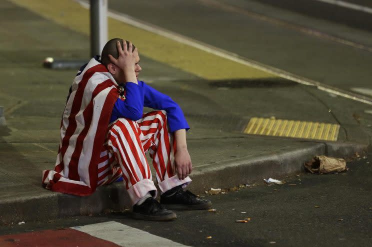A man dressed in red-white-and-blue sits on the curb during a protest against President-elect Donald Trump, Wednesday, Nov. 9, 2016, in Seattle's Capitol Hill neighborhood. (Photo: Ted S. Warren/AP)