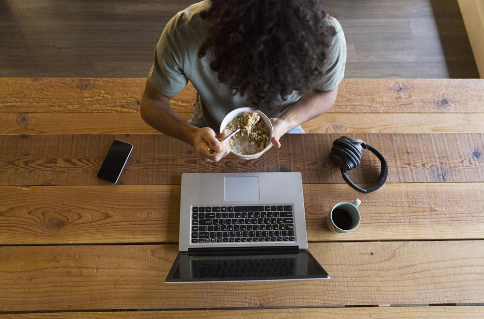 A man eating oatmeal at his desk