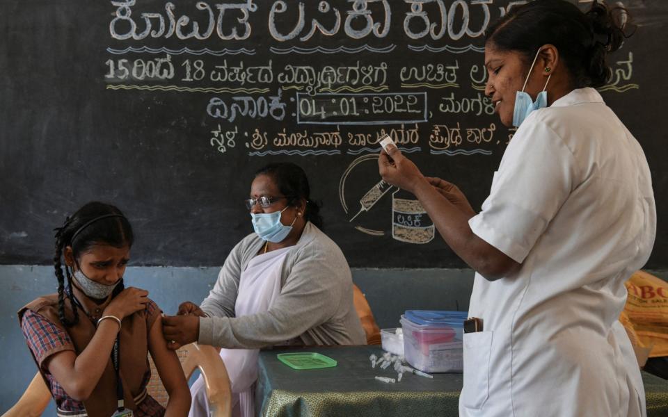 A health worker inoculates a student with a dose of the Covaxin vaccine against the Covid-19 coronavirus during a vaccination drive for youths of the 15-18 group age at a Government High School in Bangalore - MANJUNATH KIRAN /AFP