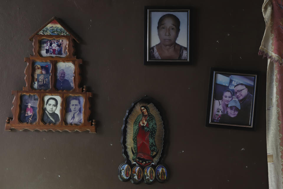 Una imagen de la Virgen de Guadalupe y fotos familiares adornan una pared en la casa de Fabricio Chicas, un hombre transgénero, en San Salvador, El Salvador, el domingo 30 de abril de 2023. Sin una legislación que permita a los hombres y mujeres transgénero modificar sus documentos oficiales en El Salvador, la comunidad enfrenta violencia y discriminación que afectan su vida cotidiana. (AP Foto/Salvador Meléndez)