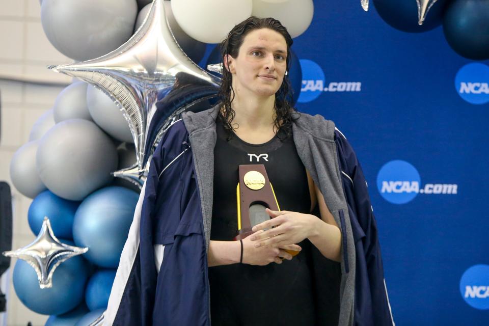 Penn swimmer Lia Thomas holds a trophy after winning the 500-yard free final on Thursday.