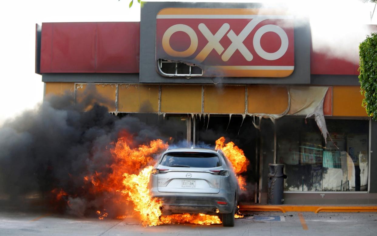 A burning care outside a store after an operation by security forces against organised crime in Celaya, Guanajuato - Sergio Maldonado/Reuters