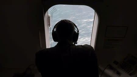 A member of the U.S. Navy, aboard the Boing P-8A Poseidon aircraft, looks down at the the South Atlantic Ocean during the search for the ARA San Juan submarine missing at sea, Argentina November 22, 2017. Picture taken November 22, 2017. REUTERS/Magali Cervantes