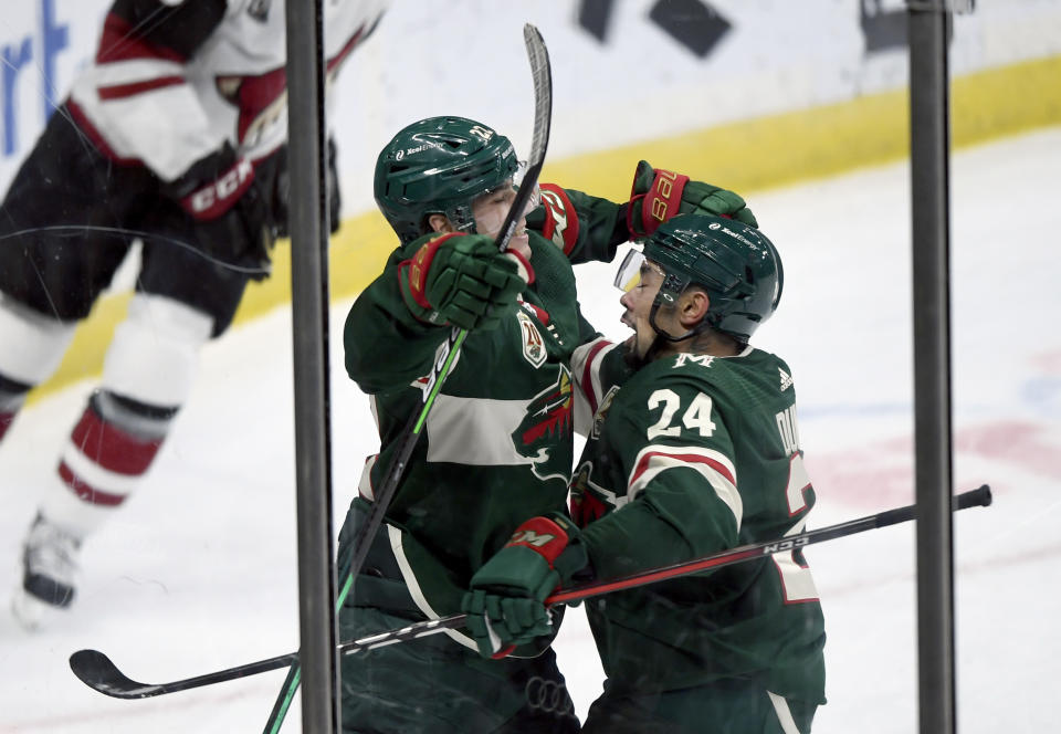 Minnesota Wild's Matt Dumba (24) congratulates teammate Kevin Fiala (22), of Switzerland, on his goal against the Arizona Coyotes during the third period of an NHL hockey game Sunday, March 14, 2021, in St. Paul, Minn. (AP Photo/Hannah Foslien)