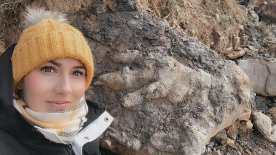 Marie Woods with the giant dinosaur footprint she found on a Yorkshire beach (Marie Woods/PA)