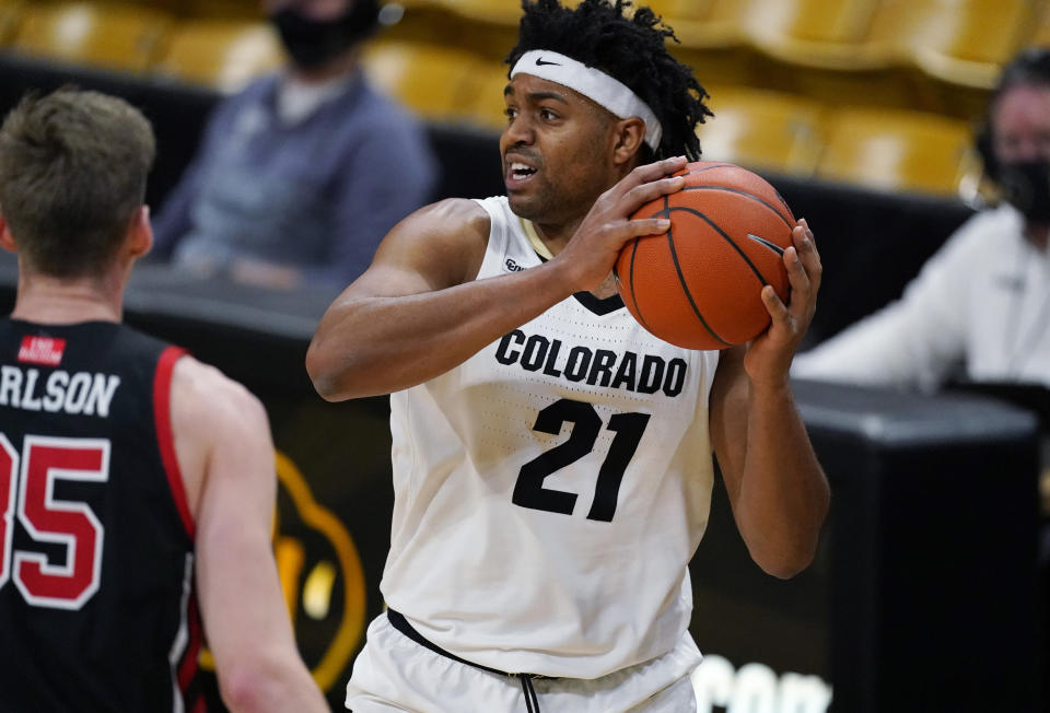 Colorado forward Evan Battey, right, looks to pass the ball as Utah center Branden Carlson defends in the second half of an NCAA college basketball game Saturday, Jan. 30, 2021, in Boulder, Colo. (AP Photo/David Zalubowski)