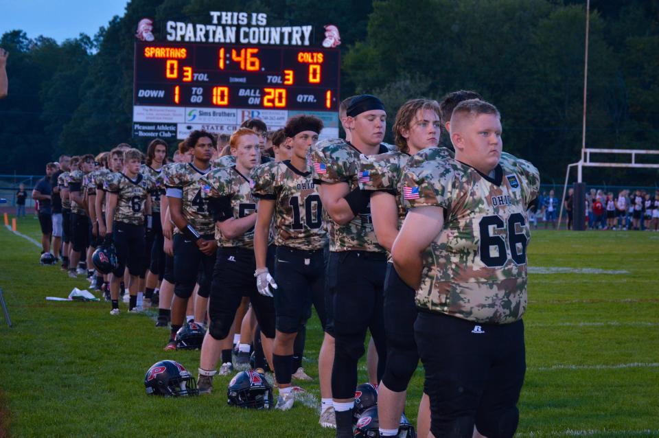 The Pleasant football team stands at attention for the national anthem before its game with Clear Fork last season.