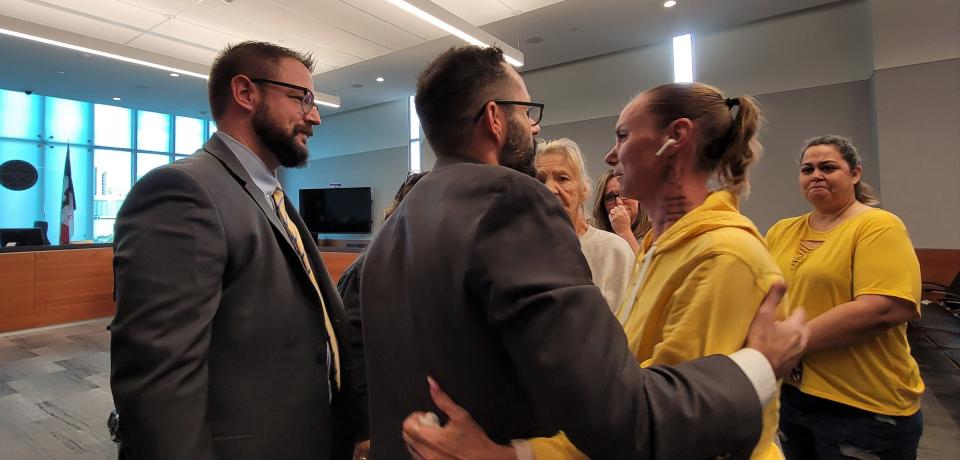 Bravon Tukes' attorneys Nicholas Bailey, left, and Jamie Deremiah, center, hug Tukes' mom Monica Woods after her son Bravon Tukes was found not guilty in January's Starts Right Here shootings.