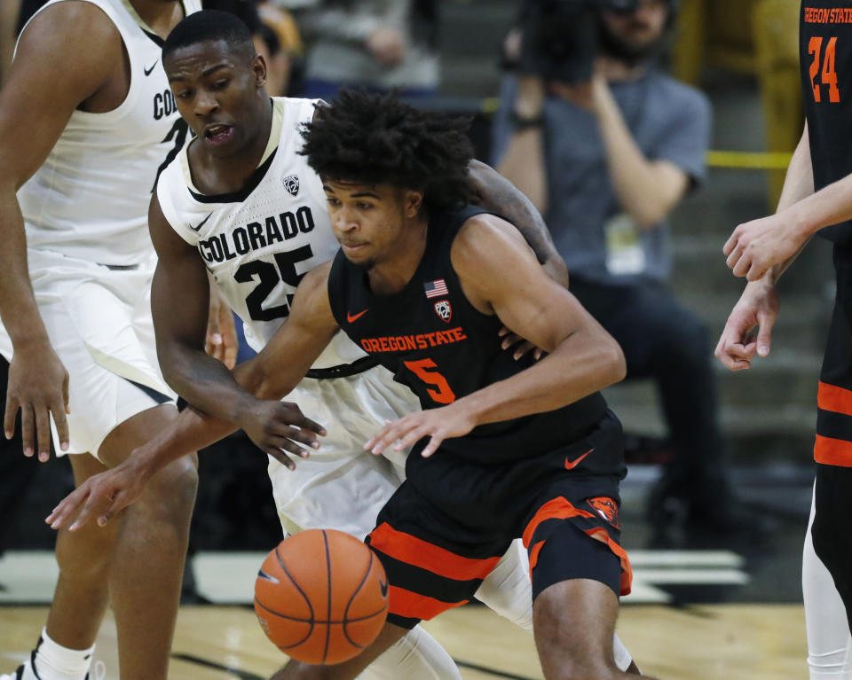 Oregon State guard Ethan Thompson, front, struggles to pull in the ball as Colorado guard McKinley Wright IV defends in the second half of an NCAA college basketball game Sunday, Jan. 5, 2020, in Boulder, Colo. (AP Photo/David Zalubowski)