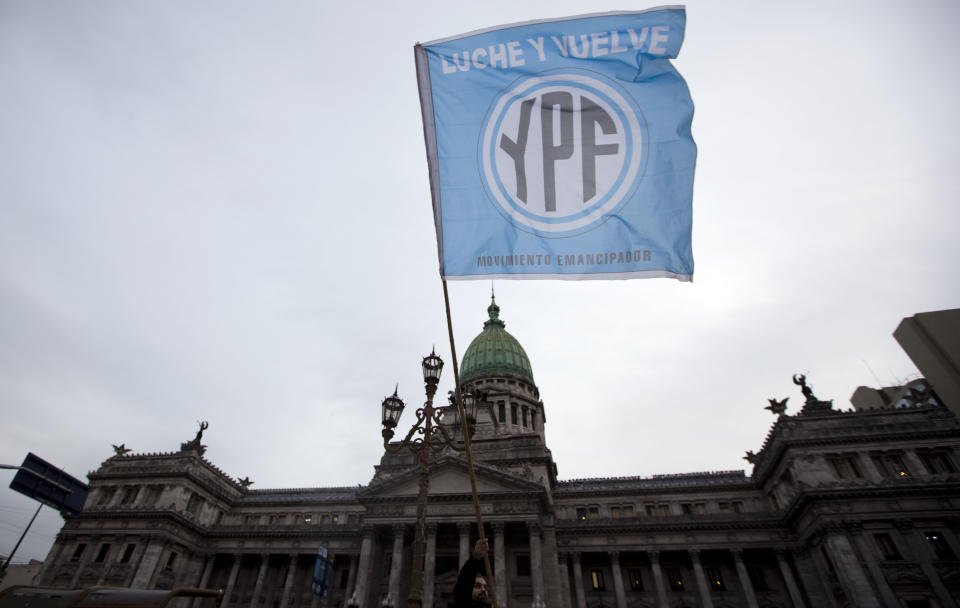 A supporters of an oil nationalization bill proposed by Argentina's President Cristina Fernandez holds a flag reading in Spanish "Fight and return YPF" outside Congress as senators debate the bill in Buenos Aires, Argentina, Wednesday, April 25, 2012. Fernandez, who pushed forward a bill to renationalize the country's largest oil company, said the legislation put to congress would give Argentina a majority stake in oil and gas company YPF by taking control of 51 percent of its shares currently held by Spain's Repsol. (AP Photo/Natacha Pisarenko)