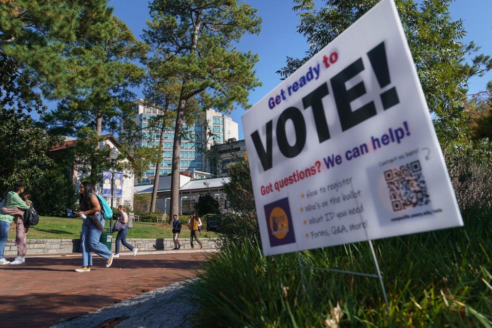 Young people pass a voting information sign on the Emory University campus in Atlanta on Oct. 14, 2022. <a href="https://media.gettyimages.com/photos/young-people-pass-a-voting-information-sign-on-the-emory-university-picture-id1244204492?s=612x612" rel="nofollow noopener" target="_blank" data-ylk="slk:Elijah Nouvelage/AFP via Getty Images;elm:context_link;itc:0;sec:content-canvas" class="link ">Elijah Nouvelage/AFP via Getty Images</a>