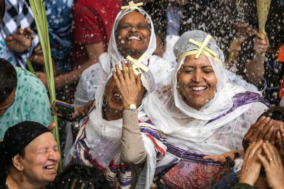 Ethiopian and Egyptian Christian worshipers are sprinkled with holy water during the Palm Sunday service.