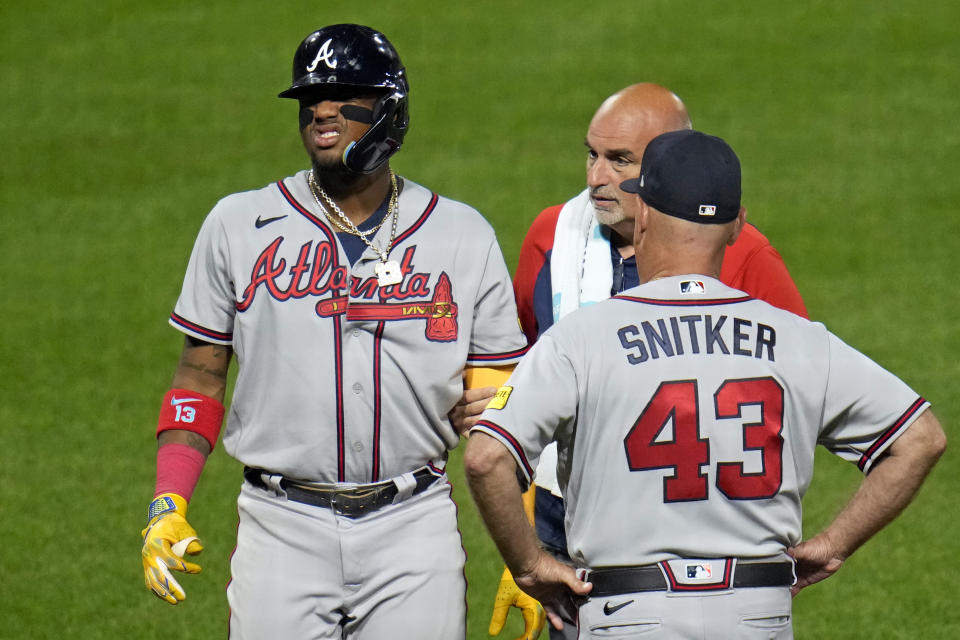 Atlanta Braves' Ronald Acuña Jr., left, grimaces as he leaves the game after being hit by a pitch from Pittsburgh Pirates' Colin Holderman during the sixth inning of a baseball game in Pittsburgh, Tuesday, Aug. 8, 2023. (AP Photo/Gene J. Puskar)