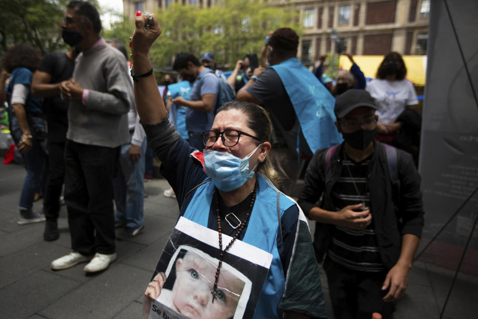 A woman wearing and holding up a rosary celebrates the Supreme Court's decision against an injunction in Veracruz state that aimed to decriminalize abortion for all cases within the first 12 weeks of pregnancy, outside the Supreme Court in Mexico City, Wednesday, July 29, 2020. Two of Mexico’s 32 states have decriminalized abortion. (AP Photo/Fernando Llano)