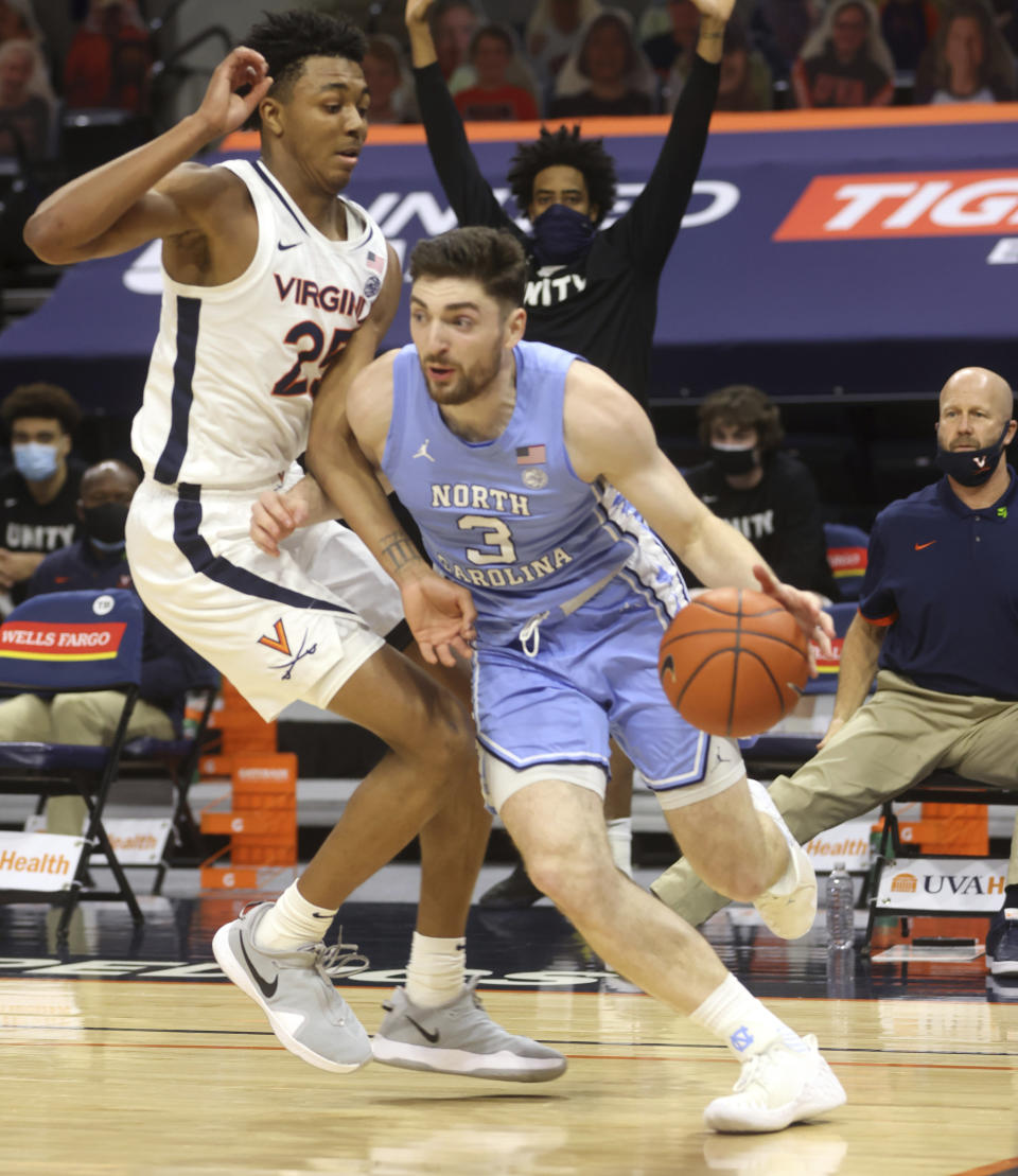 North Carolina guard Andrew Platek (3) moves past Virginia guard Trey Murphy III (25) during an NCAA college basketball game Saturday, Feb. 13, 2021, in Charlottesville, Va. (Andrew Shurtleff/The Daily Progress via AP, Pool)