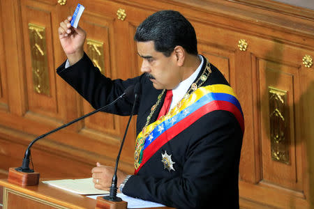 Venezuela's President Nicolas Maduro holds a copy of the National Constitution while he speaks during a special session of the National Constituent Assembly to take oath as re-elected President at the Palacio Federal Legislativo in Caracas, Venezuela May 24, 2018. REUTERS/Marco Bello