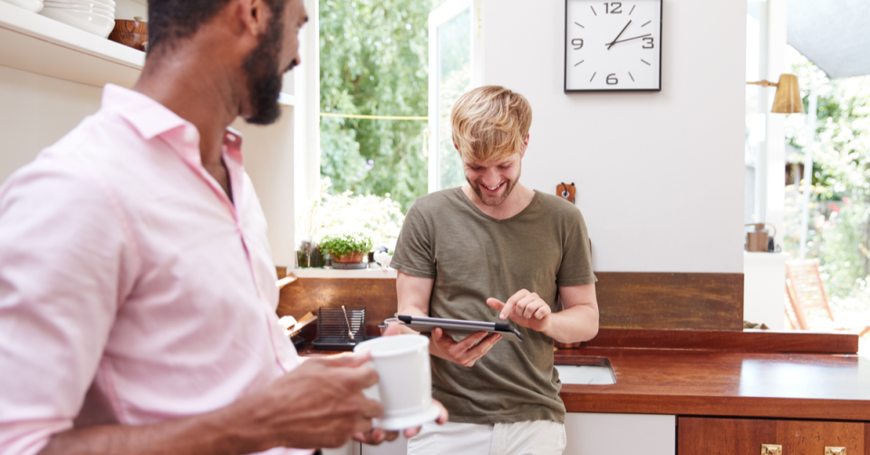 Two men in the kitchen talk about the stock market and investing in their 401(k) accounts