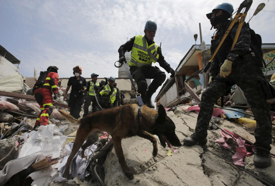 <p>A Mexican federal police officer © and other team rescue members search for victims at a collapsed store at the village of Manta, after an earthquake struck off Ecuador’s Pacific coast, April 21, 2016. (Henry Romero/Reuters)</p>