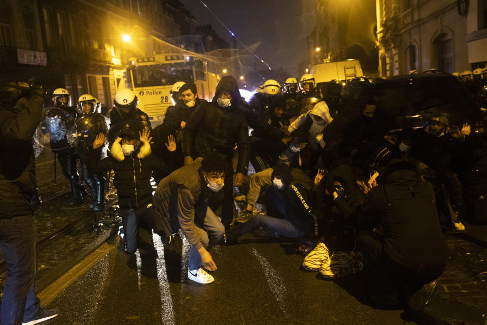 Protesters are blocked by police officers during clashes in the Belgium capital, Brussels, Wednesday, Jan. 13, 2021, at the end of a protest asking for authorities to shed light on the circumstances surrounding the death of a 23-year-old Black man who was detained by police last week in Brussels. The demonstration in downtown Brussels was largely peaceful but was marred by incidents sparked by rioters who threw projectiles at police forces and set fires before it was dispersed. (AP Photo/Francisco Seco)