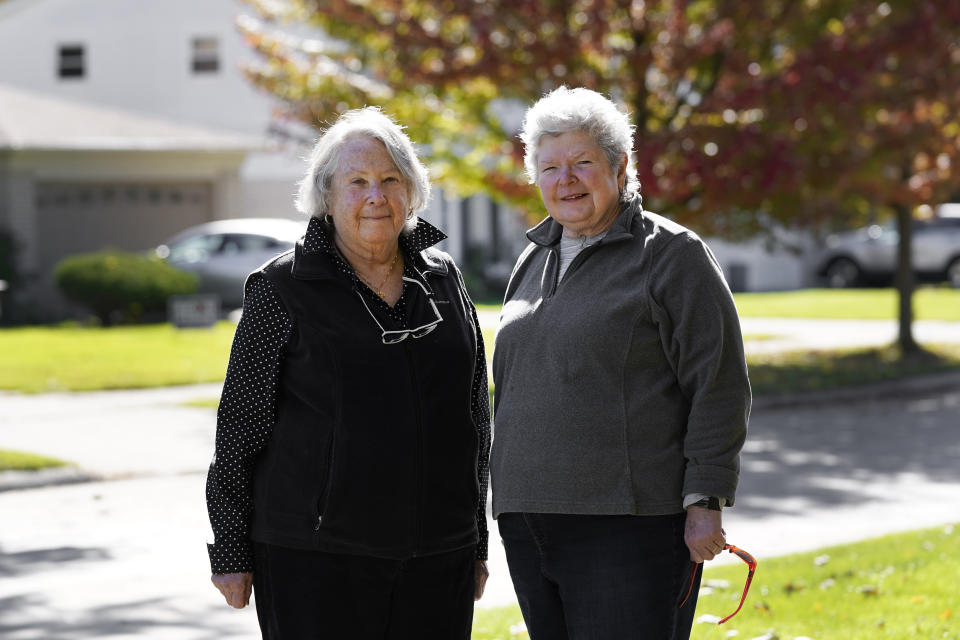 Ellen Ehrlich and Linda Northcraft pose for a portrait in Southfield, Mich., Tuesday, Oct. 13, 2020. They became active in Democratic politics when Gretchen Whitmer was running for governor. Before dinner, they pray for people sick from COVID, for Biden and Harris, and, until recently, for Justice Ruth Bader Ginsburg. (AP Photo/Paul Sancya)