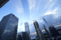 The Evergrande headquarters, left, stands in Shenzhen, China, Friday, Sept. 24, 2021. Seeking to dispel fears of financial turmoil, some Chinese banks are disclosing what they are owed by a real estate developer that is struggling under $310 billion in debt, saying they can cope with a potential default. (AP Photo/Ng Han Guan)