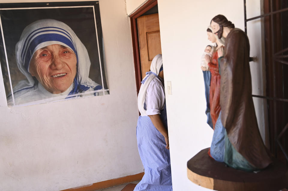 A sister of the Missionaries of Charity order, who is one of the 18 nuns expelled last year from Nicaragua, walks past a poster of St.Teresa of Calcutta, in a parish home in Las Canas, Costa Rica, Wednesday, March 1, 2023. After more than 30 years of serving in Nicaragua, the organization was stripped of its legal status and its members were escorted to the Costa Rican border. (AP Photo/Carlos Gonzalez)
