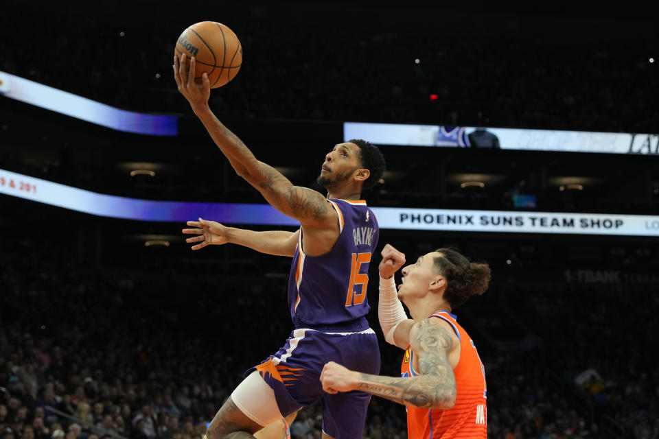 Phoenix Suns guard Cameron Payne (15) drives past Oklahoma City Thunder forward Lindy Waters III during the first half of an NBA basketball game, Wednesday, March 8, 2023, in Phoenix. (AP Photo/Rick Scuteri)
