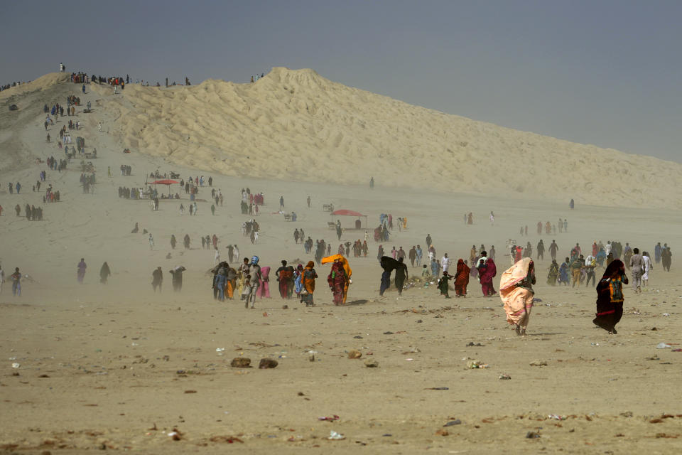 Hindu devotees walk toward a mud volcano, to start Hindu pilgrims' religious rituals for an annual festival in an ancient cave temple of Hinglaj Mata in Hinglaj in Lasbela district in the Pakistan's southwestern Baluchistan province, Friday, April 26, 2024. More than 100,000 Hindus are expected to climb mud volcanoes and steep rocks in southwestern Pakistan as part of a three-day pilgrimage to one of the faith's holiest sites. (AP Photo/Junaid Ahmed)