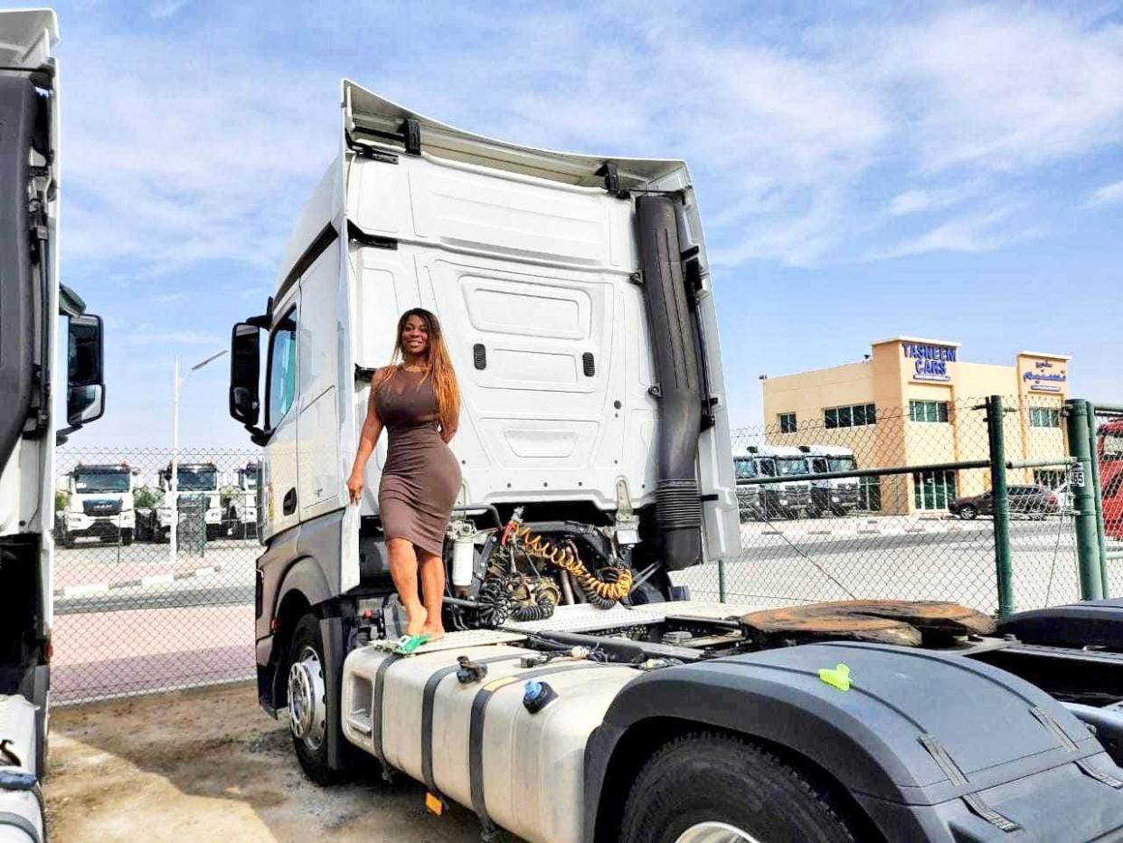 Tierra Allen stands on the back of a semi truck while testing out trucks in Dubai.