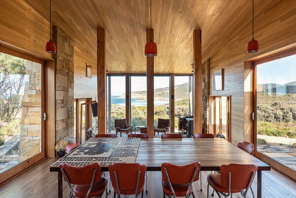 Floor-to-ceiling windows and large sliding glass doors wrap around the main living areas.