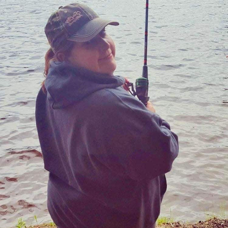 Stephanie Clark fishing with a baseball cap a few years before her diagnosis