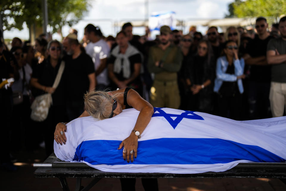 Antonio Macías' mother cries over her son's body, covered with the Israeli flag, at Pardes Haim cemetery in Kfar Saba, Israel, Sunday, Oct. 15, 2023. Macias was killed when Hamas unleashed its attack on thousands of Jews attending a music festival in southern Israel earlier this month. (AP Photo/Francisco Seco)