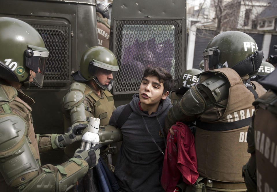 <p>A high school student is detained during a protest for education reform in Santiago, Chile, July 28, 2016. Protesters demands include free access to school for all ages, including university level. (Photo: Esteban Felix/AP)</p>