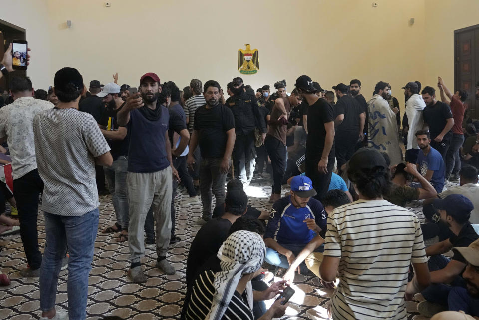 Iraqi security forces standby as protesters enter the Government Palace during a demonstration in Baghdad, Iraq, Monday, Aug. 29, 2022. Muqtada al-Sadr, a hugely influential Shiite cleric announced he will resign from Iraqi politics and his angry followers stormed the government palace in response. The chaos Monday sparked fears that violence could erupt in a country already beset by its worst political crisis in years. (AP Photo/Hadi Mizban)