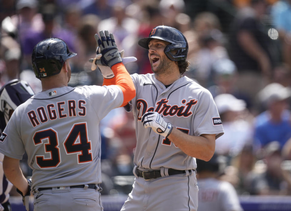 Detroit Tigers' Jake Rogers, left, congratulates Jake Marisnick who crosses home plate after hitting a grand slam off Colorado Rockies relief pitcher Brad Hand in the eighth inning of a baseball game Sunday, July 2, 2023, in Denver. (AP Photo/David Zalubowski)